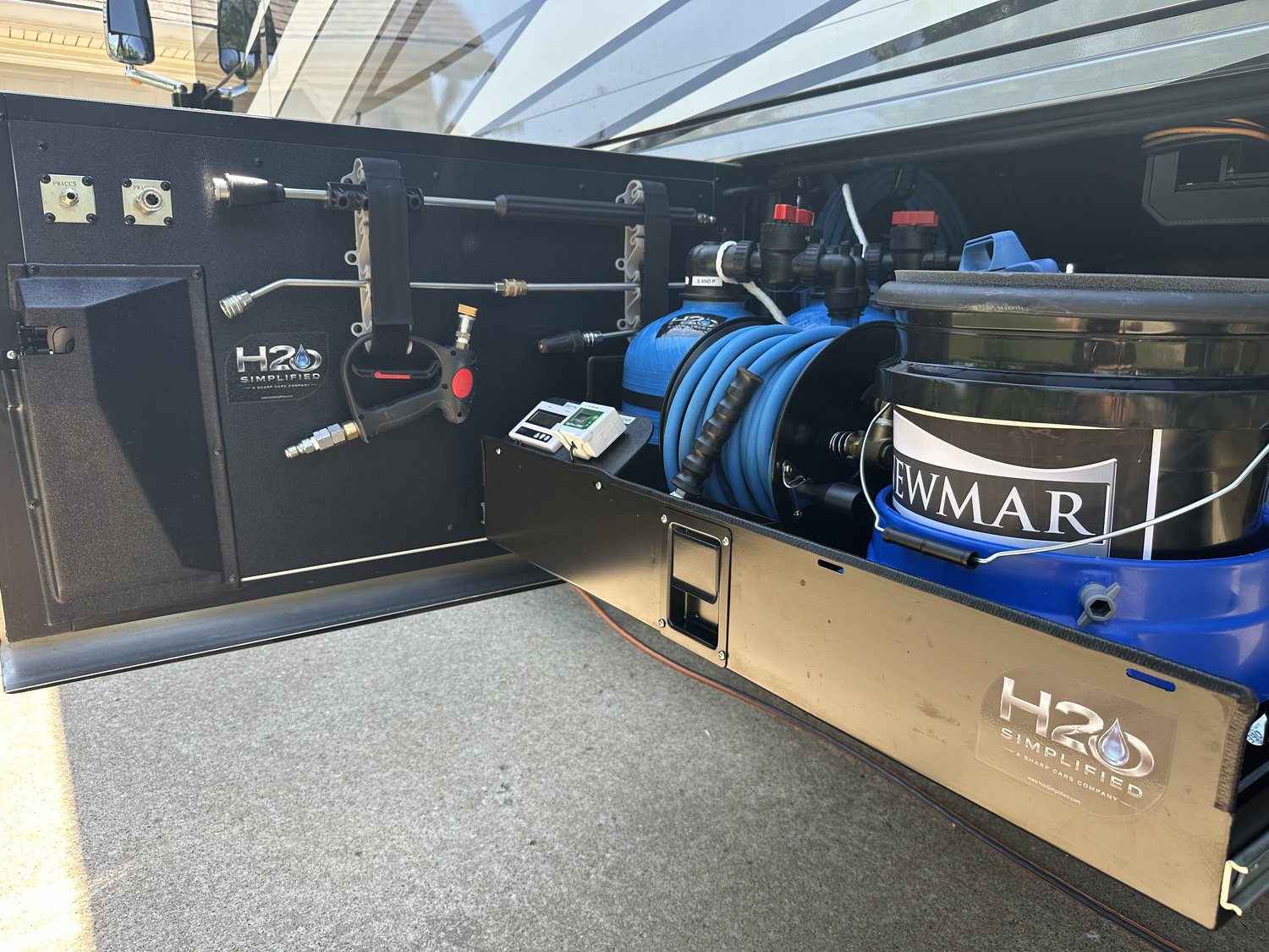 H2O Simplified water softener, filtration and spot-free rinse with hose reel built into a Newmar coach bay